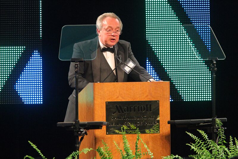 Speaker at a podium with presidential teleprompters